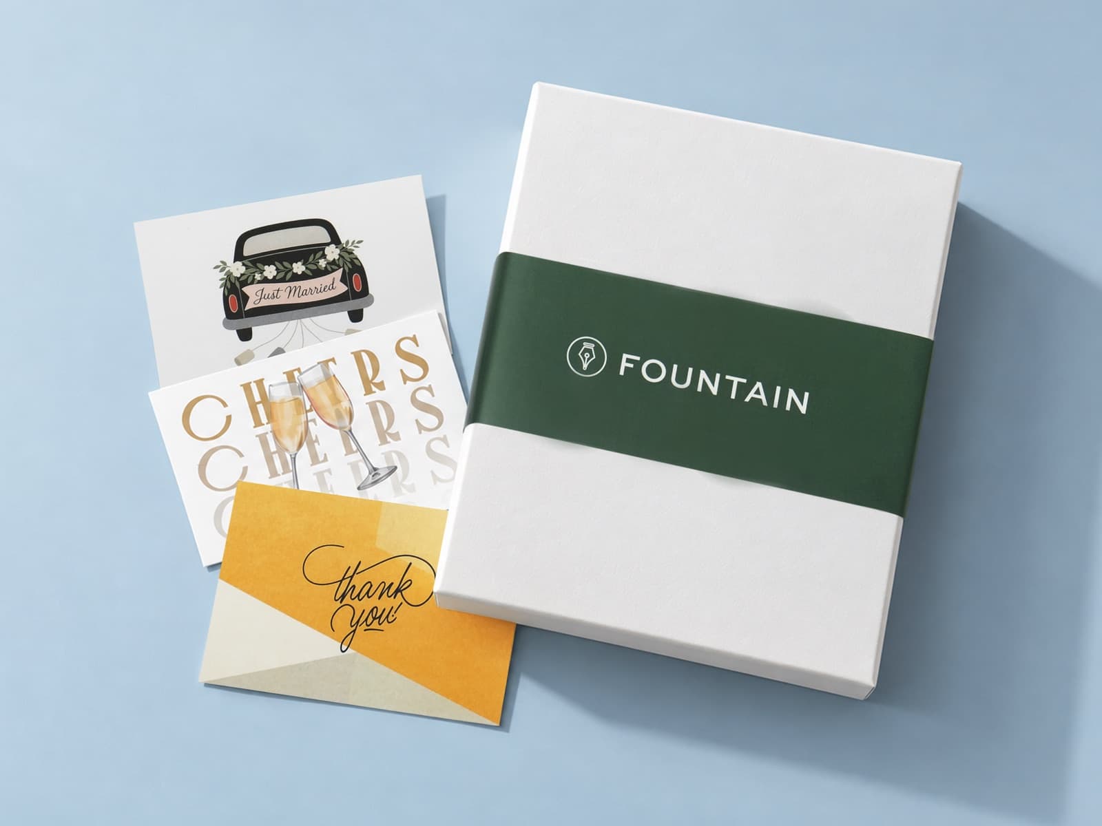 Our white gift box with the Fountain band, beside three printed cards