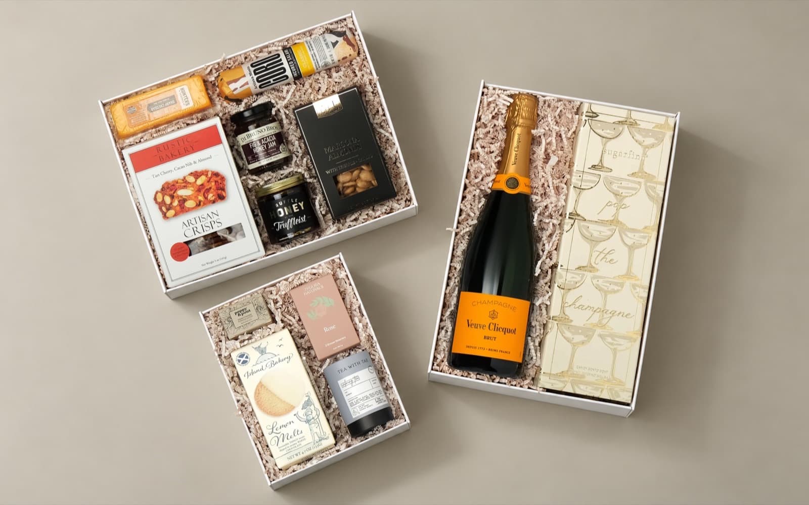 Three open gift boxes of snacks and treats